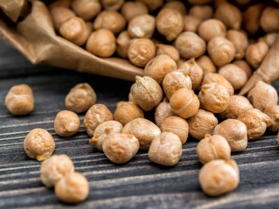 Raw chickpeas in paper bag on wooden background. Healthy food